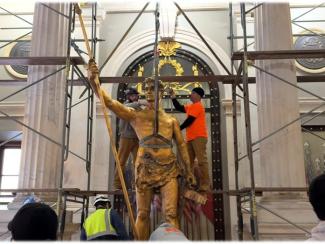 independent man statue inside with scaffolding 