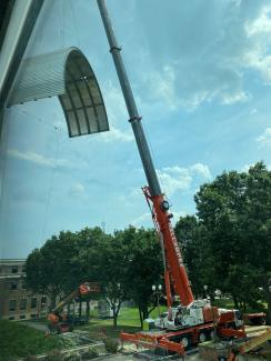 crane lifting large metal entrance covering