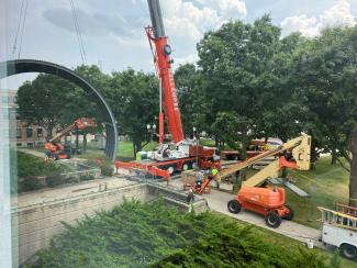 crane lifting large metal entrance covering
