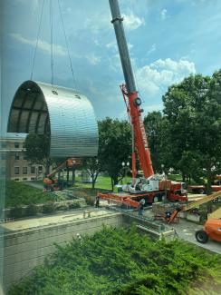 crane moving large metal entrance covering