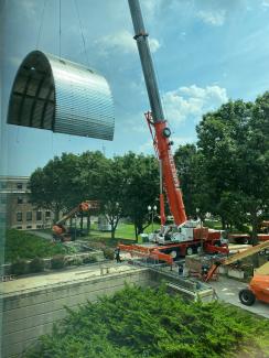 crane moving large metal entrance covering
